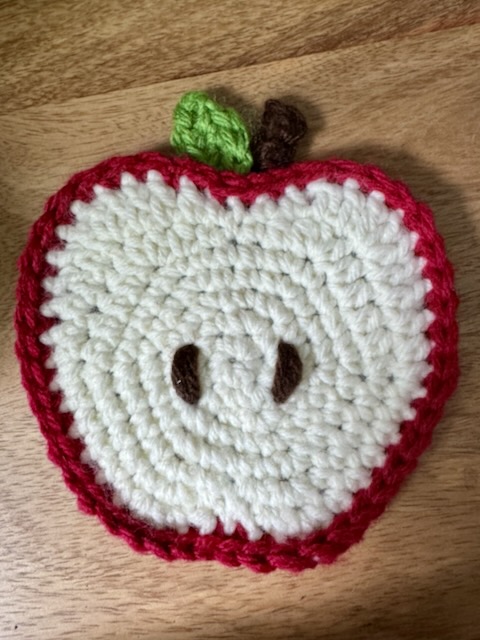 Completed apple crochet coaster in red